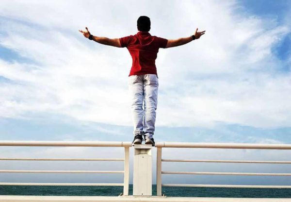 Finanzielle Unabhängigkeit und Freiheit im Check. Bild: https://www.pexels.com/photo/person-raising-hands-mid-air-sidewards-while-standing-on-gray-steel-railings-680257/ Autor: Sanketh Rao